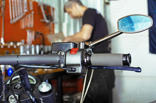Side view portrait of man working in garage repairing motorcycle