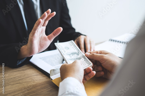 Anti bribery and corruption concept, Business man refusing and don't receive money banknote offered from business people to accept agreement contract of investment deal