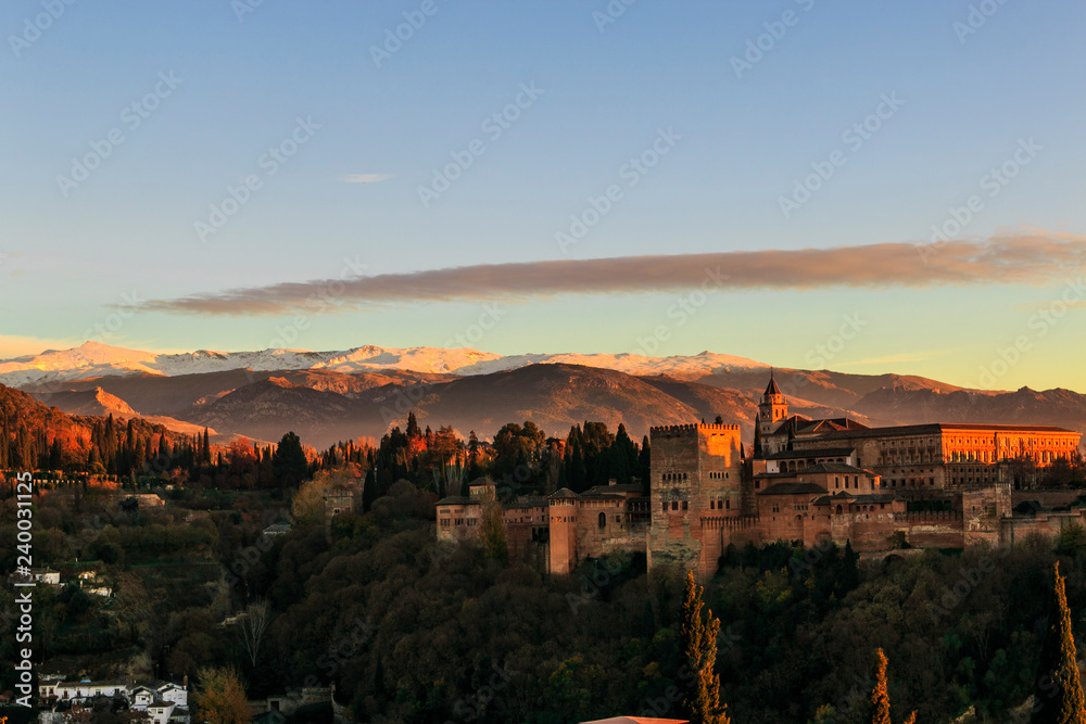 Alhambra Palace in Granada, Andalucia, Spain. Sierra Nevada mountains at the background. Golden hour at sunset.