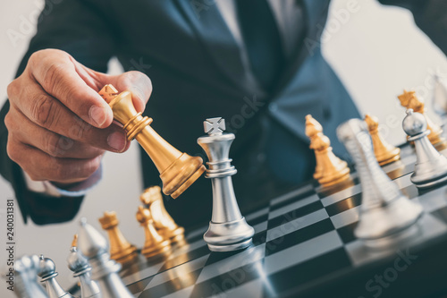 Foto Businessman leadership playing chess and thinking strategy plan about crash over