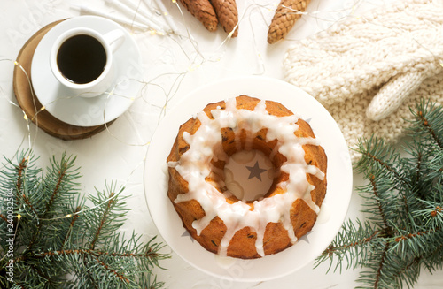 Obraz na płótnie Pie with raisins and icing from powdered sugar on the background of fir branches and garlands. Rustic style. w salonie