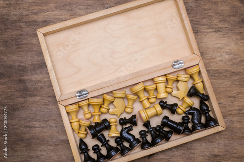 Open chess box with some black and white chess figures inside photo