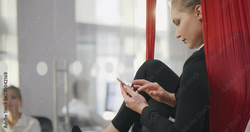Portrait of business woman in formal wear sitting in hammock Portrait of business woman in formal wear sitting in hammock