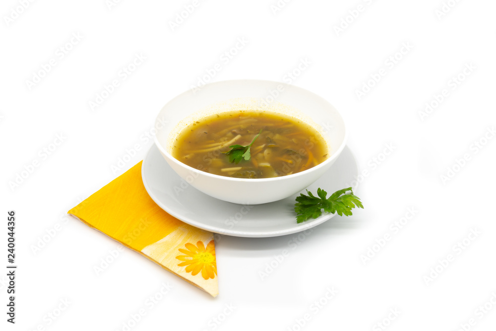 A delicious soup dish with pasta and vegetables, decorated with parsley, over a orange napkin and with a large and clean white background A delicious soup dish with pasta and vegetables, decorated with parsley, over a orange napkin and with a large and clean white background