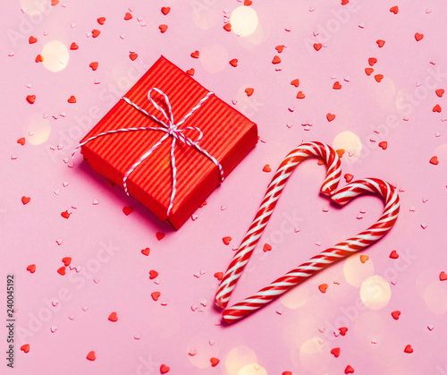 Pink holiday background with present gift box and little hearts on background. Valentine's day greeting concept. photo