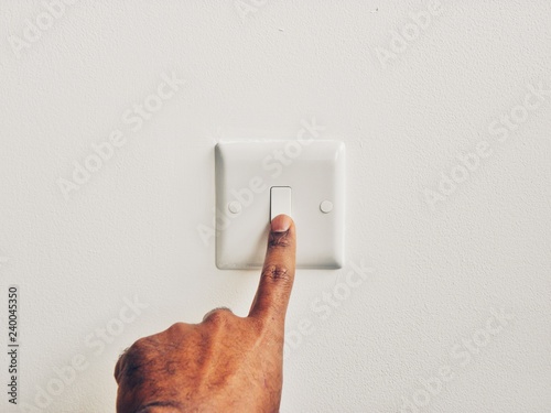hand with switch on wall