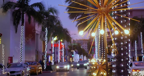 A nighttime establishing shot of the Christmas-decorated streets of Rodeo Drive.  	