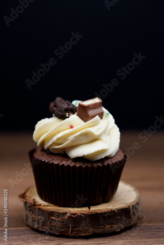 Chocolate, tasty and sweet cupcake with vanilla cream and condensed milk inside. Minimal food bakery concept.