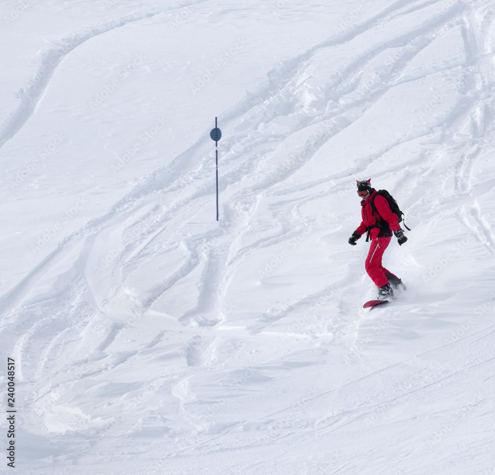 Snowboarder descends on snowy off-piste slope