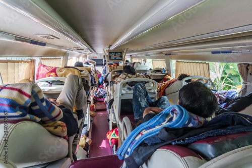 reportage shot of man watching TV in long distance sleeper bus i