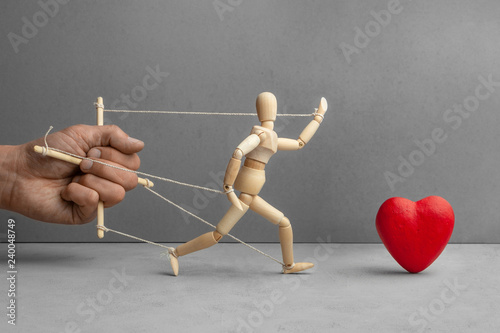 Fotografi Containment manipulation of puppet that tends to the red heart