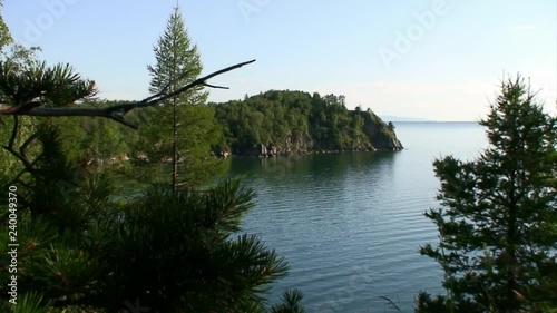 Green trees of taiga on rocky coastline of deepest freshwater lake Baikal. photo