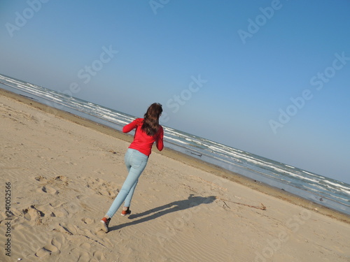 girl runs along beach
