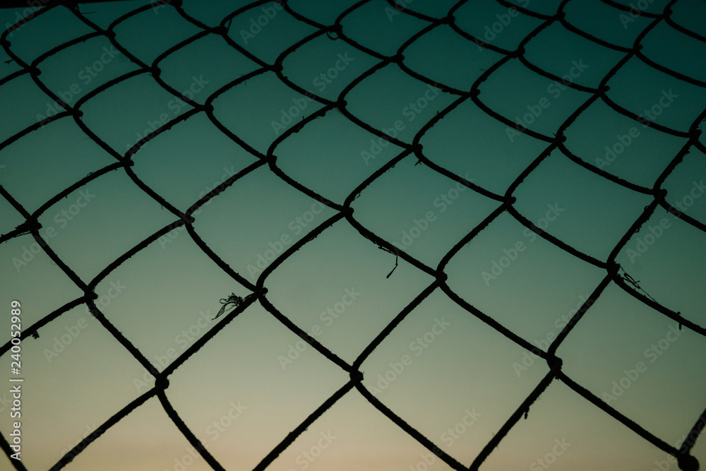 Old metal mesh against the evening sky. Abstract background Old metal mesh against the evening sky. Abstract background