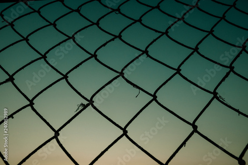 Old metal mesh against the evening sky. Abstract background