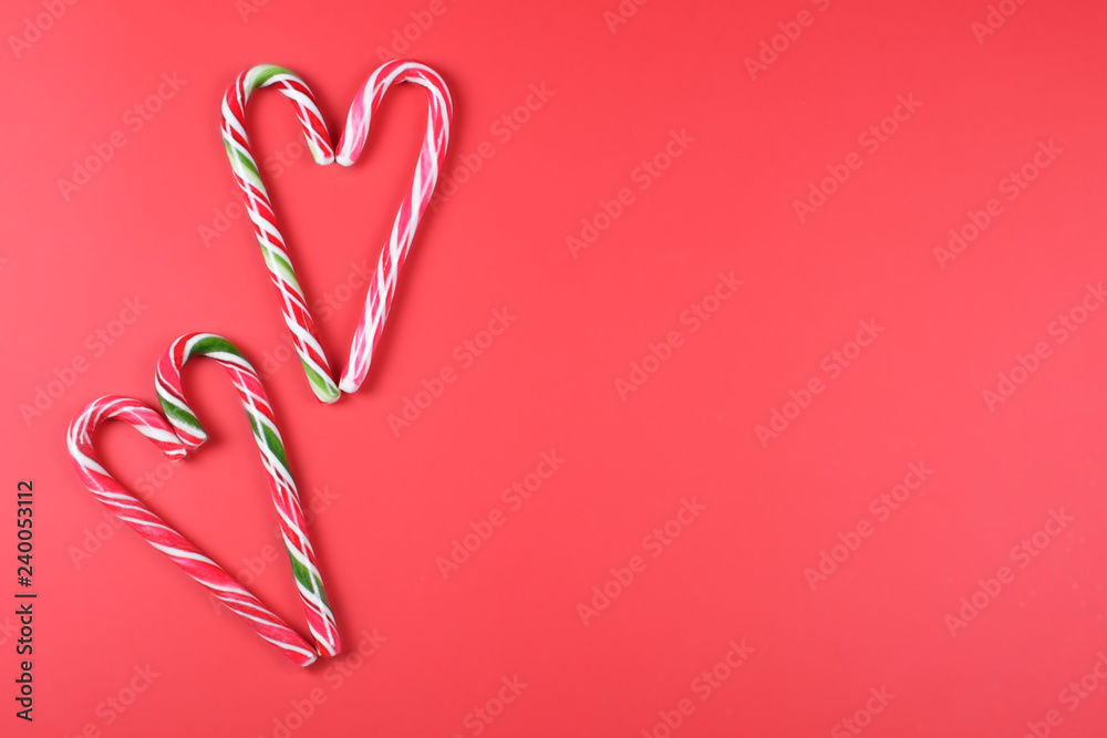 Four candy canes on red background.