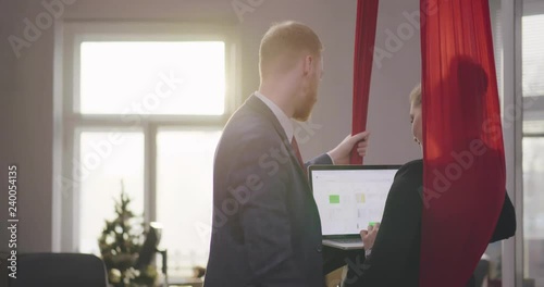 Athletic business lady consulting with a male colleague