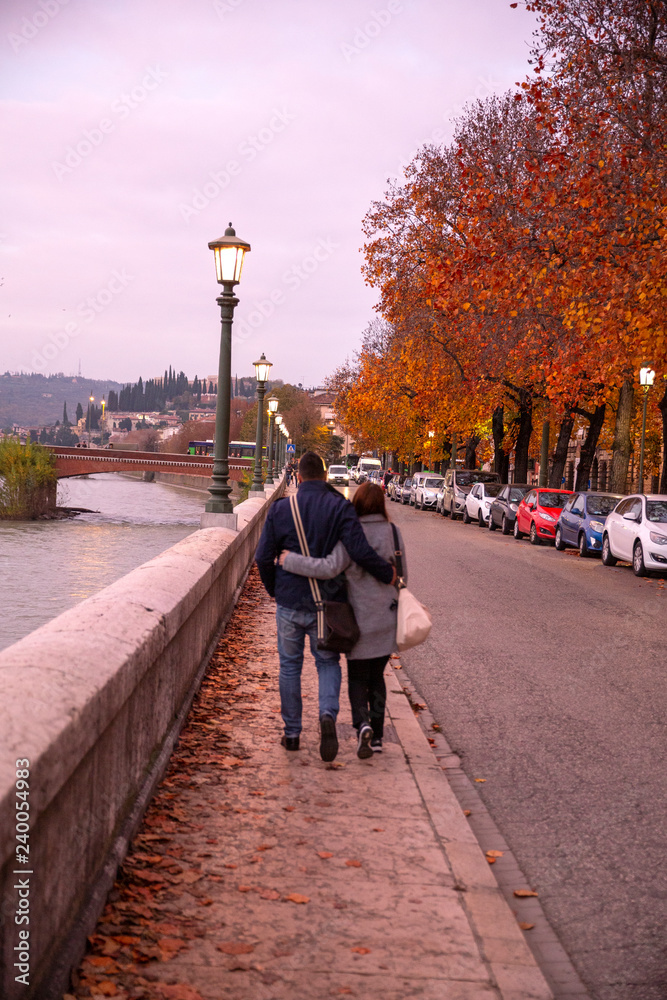 couple in love walking in the autumn streets of Verona. Stylish young couple walking on european autumn streets , have fun and hugging. Wearing trendy season outfit.
