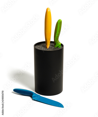 Three colored kitchen knives in stand on white background