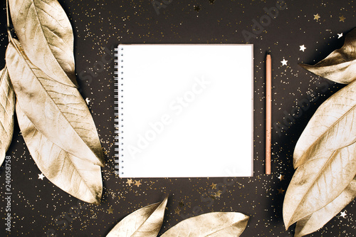 Goal lift for New Year. Holiday decorations and notebook with clean note book on dark table  flat lay style. Planning concept.