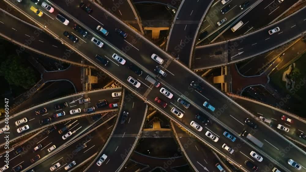 Rising drone shot reveals spectacular elevated highway and convergence of roads, bridges, viaducts in Shanghai at night, transportation and infrastructure development in urban China
