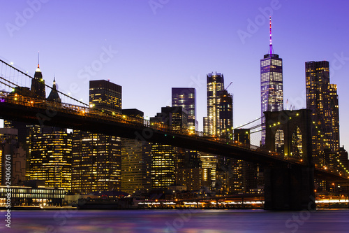 Beautiful Brooklyn Bridge and the illuminated Manhattan's skyline at dusk with dark blue sky and smooth water surface. Picture taken from the Brooklyn district, New York, USA. © Travel Wild
