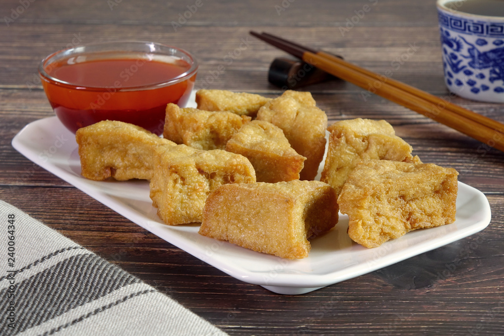 Naklejka premium Tofu. Traditional fried Tofu , served with sweet chili sauce or sweet plum sauce. Famous Chinese appitizer / Chinese cuisine. Vegetarian food.