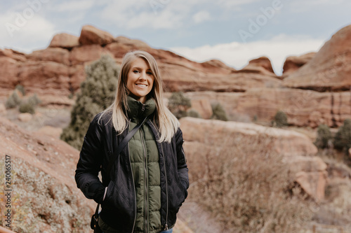 Young Beautiful Modern Caucasian Woman Smiling While Traveling to Red Rocks Park in United States Outside in Nature at the State Park with Ancient Stone and Blue Sky Background © MeganMahoneyPhotos