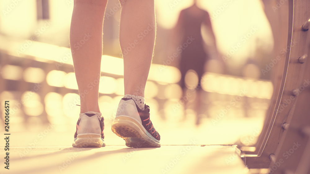 Sporty girl running on road at sunrise. Fitness and workout wellness concept.