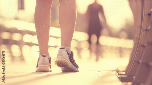 Sporty girl running on road at sunrise. Fitness and workout wellness concept.