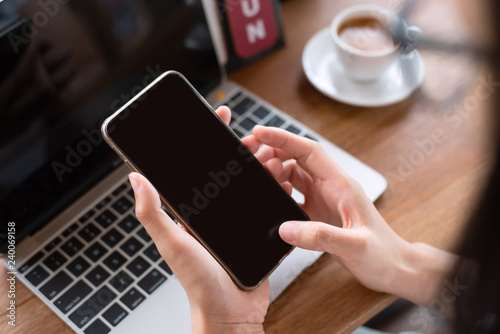 woman hand using a smartphone in the holiday at coffee shop.