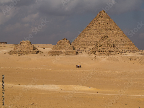 Three small pyramids in front of a larger pyramid in Cairo  Egypt