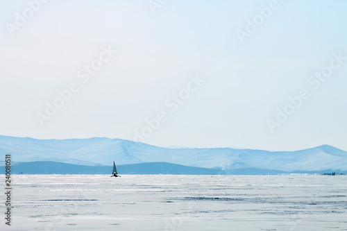 Ice boat rides on the ice of Lake Baikal in the background Olkhon in the winter foggy morning away