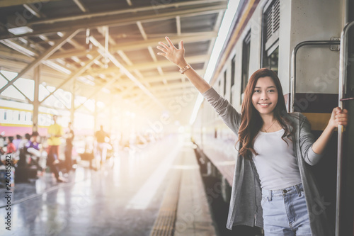 Asian woman tourist backpacker is waving goodbye to her friend after traveling together during the holidays.