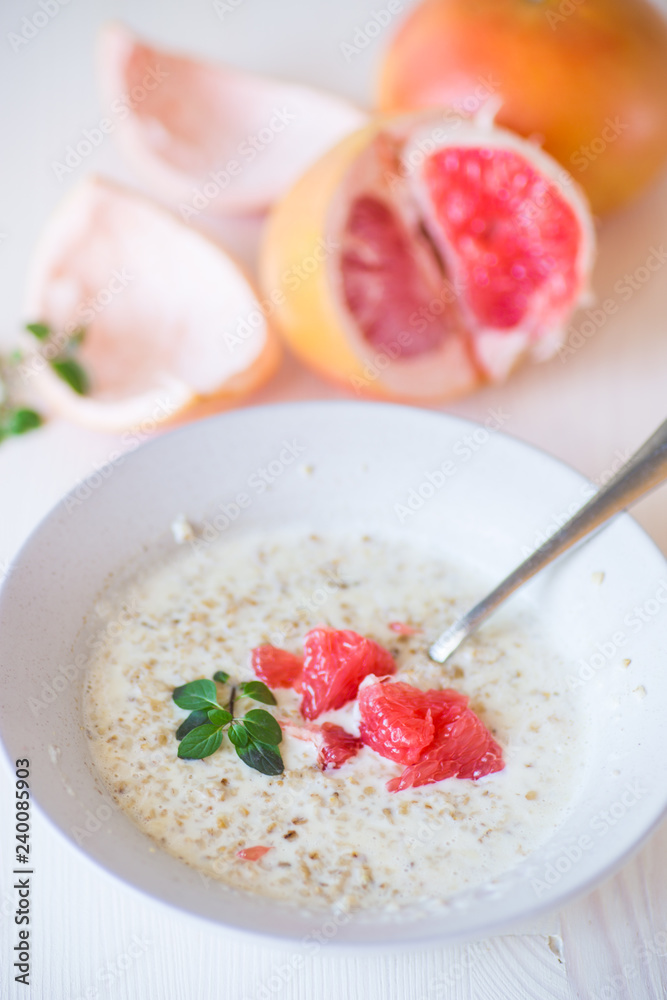 sweet oatmeal with slices of red grapefruit in a ceramic bowl sweet oatmeal with slices of red grapefruit in a ceramic bowl