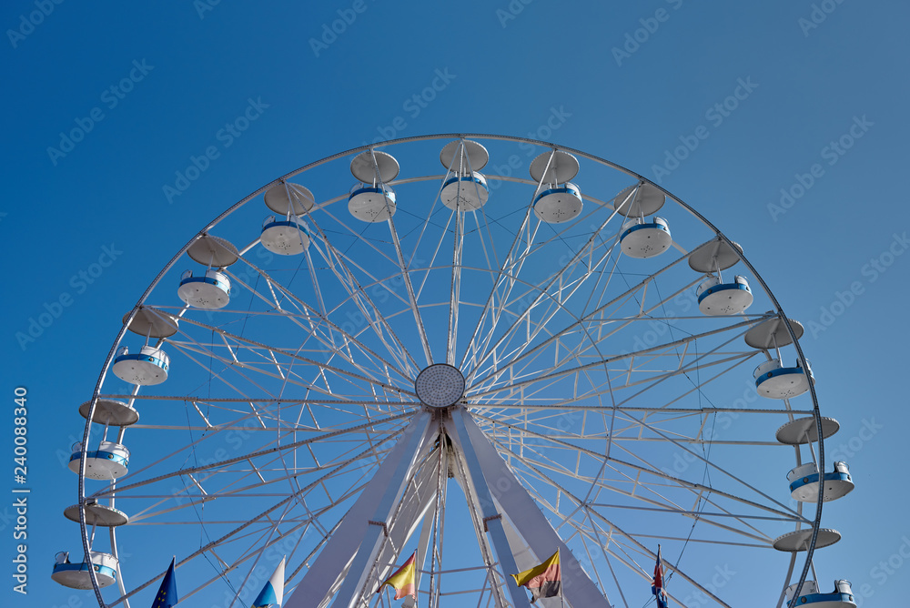 Ferris wheel with flags of several country in amusement park. Front view image.