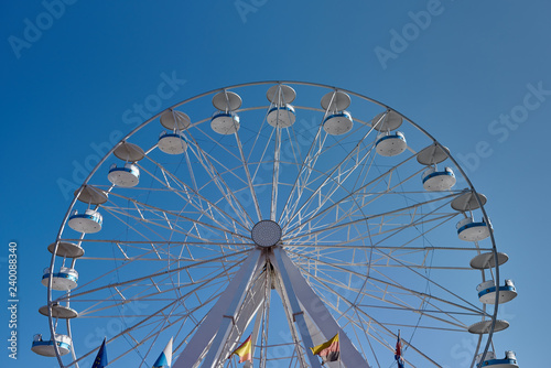 Ferris wheel with flags of several country in amusement park. Front view image.