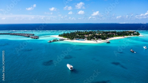 Aerial view of island white sand beach and blue lagoon in Maldives resort.