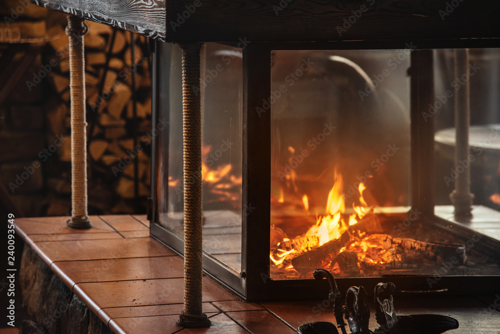 Burning fireplace and woodpile. Warm atmosphere