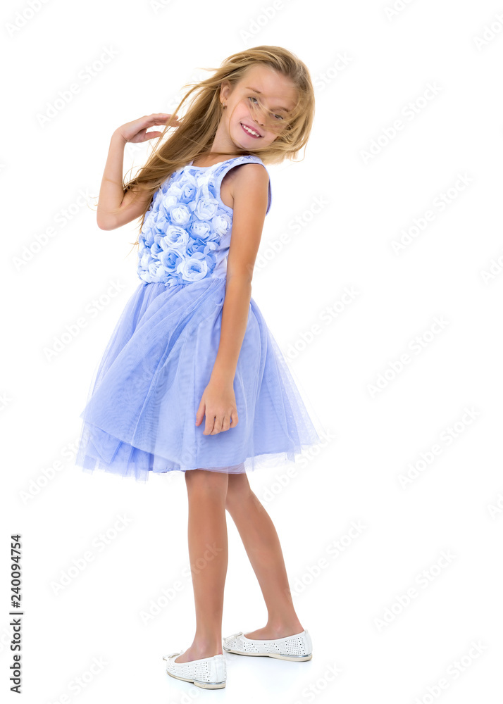 Little girl in a dress developing in the wind.