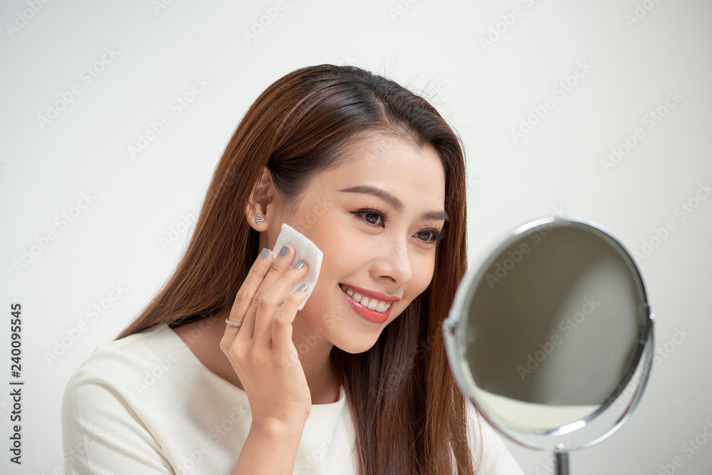 beautiful girl cleans the face of makeup with a cotton pad beautiful girl cleans the face of makeup with a cotton pad