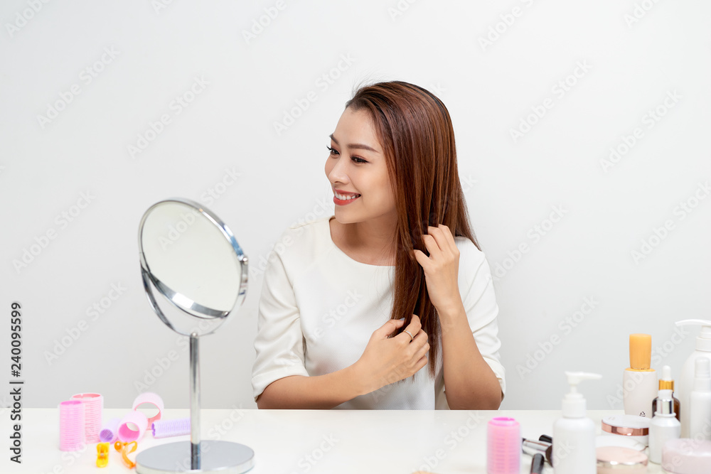 Portrait of brunette woman looking at her face in mirror Portrait of brunette woman looking at her face in mirror