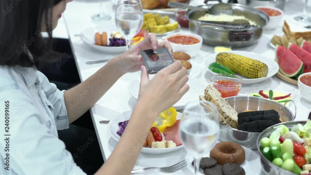 Chinese woman eating dinner and using smartphone take photo with food on table. Concept of festival, birthday, happy new year and christmas. 4k resolution. Chinese woman eating dinner and using smartphone take photo with food on table. Concept of festival, birthday, happy new year and christmas. 4k resolution.