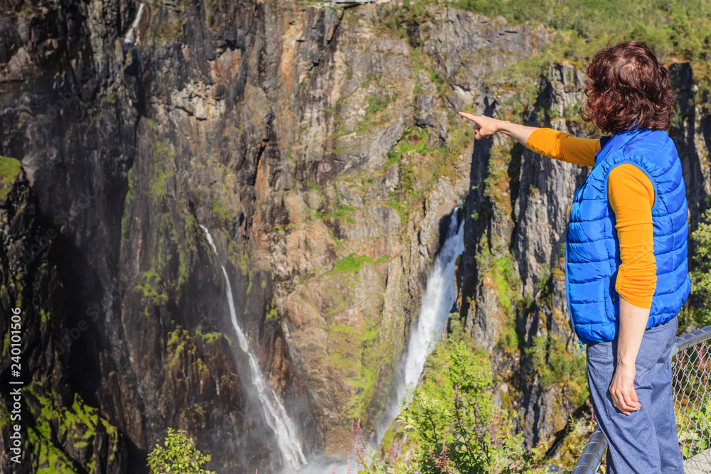 Tourist woman by Voringsfossen waterfall, Norway Tourist woman by Voringsfossen waterfall, Norway