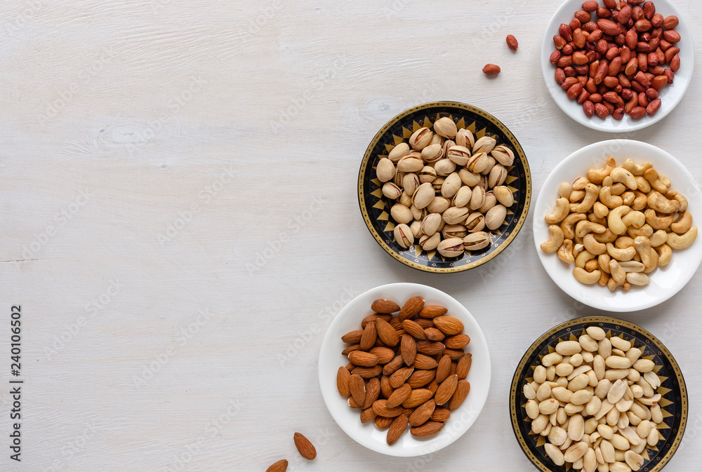 Corner border of fresh nuts in individual bowls Corner border of fresh nuts in individual bowls