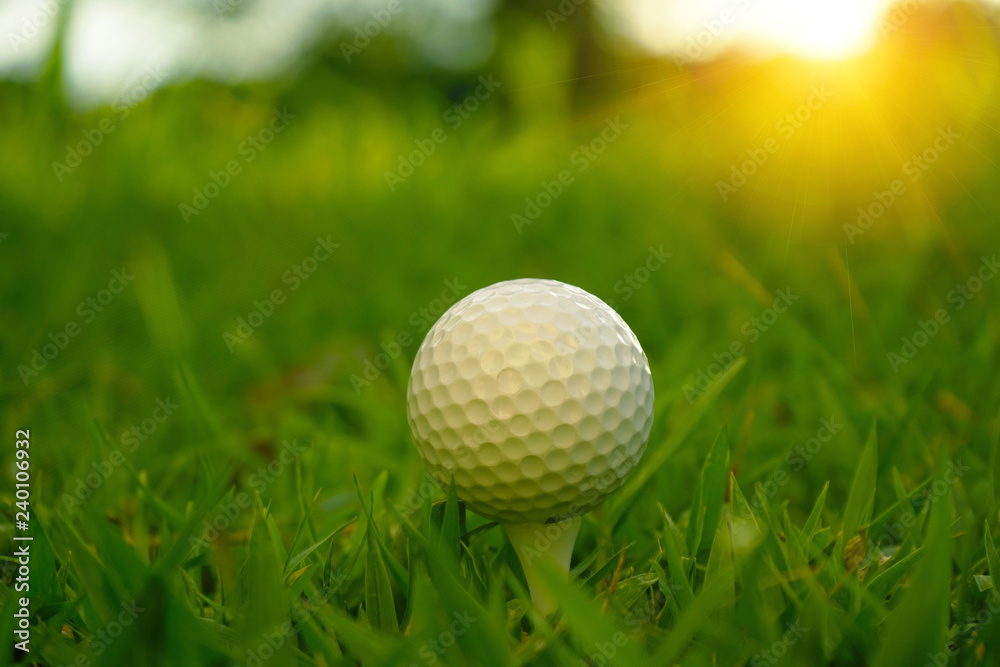 Blurred golf ball on tee in beautiful golf course at sunset background. Blurred golf ball on tee in beautiful golf course at sunset background.