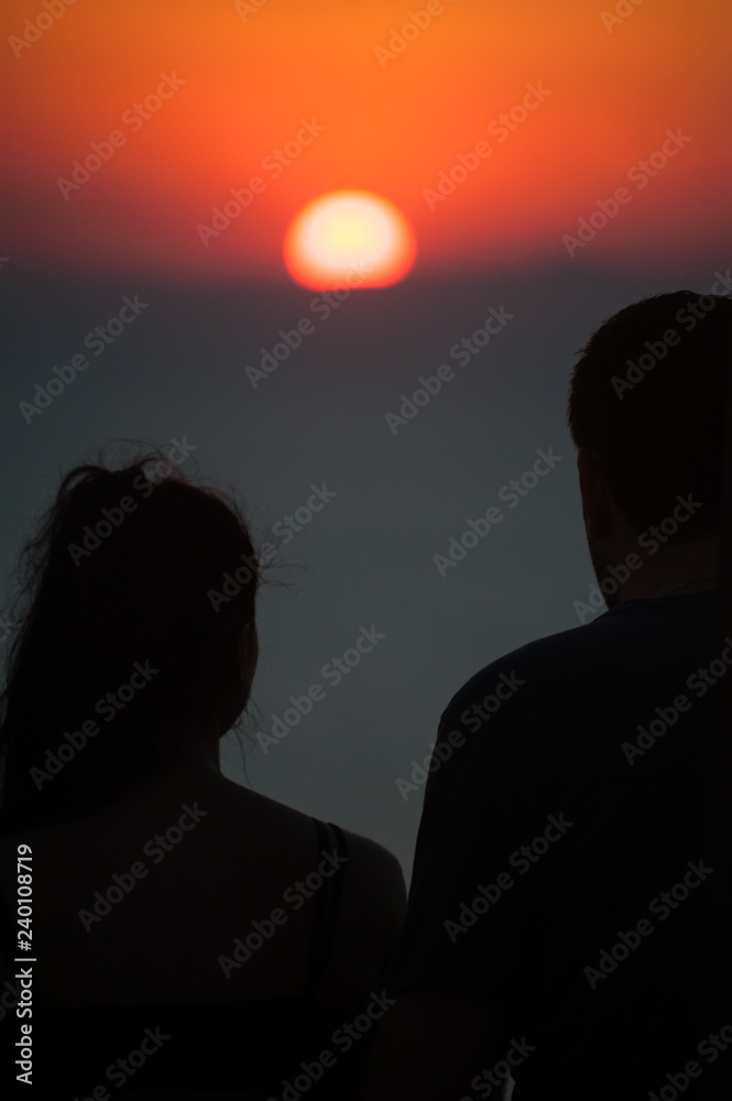 Silhouette of man and woman watching the sunset