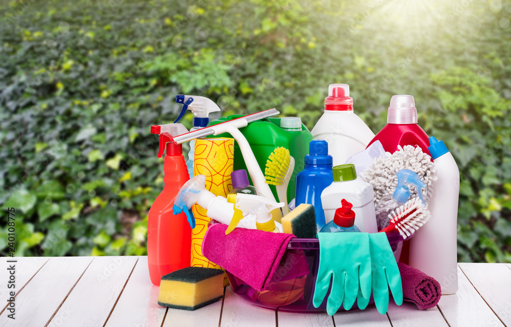 Cleaning products in basket, background green forest Cleaning products in basket, background green forest