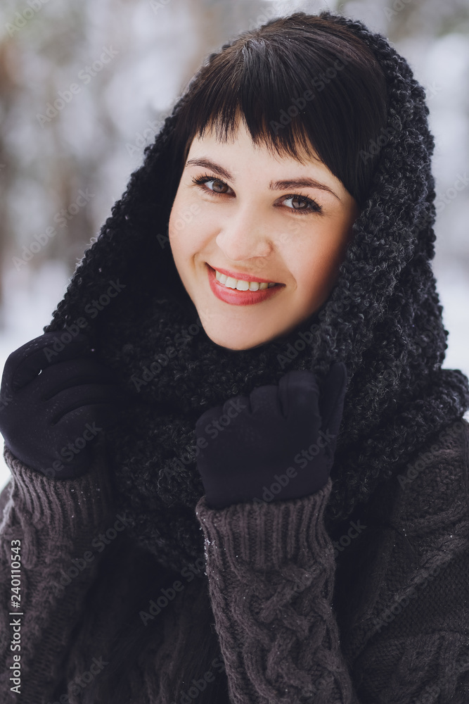 Young beautiful brunette girl in a sweater in the winter snowy forest Young beautiful brunette girl in a sweater in the winter snowy forest