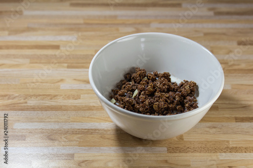 Chocolate corn flake with white and brown chocolate in white bowl on wooden desk